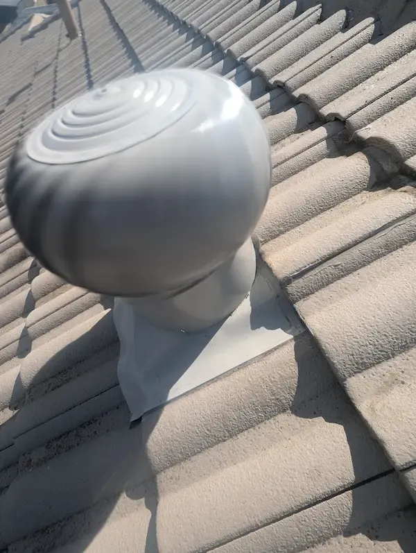 Silver whirlybird turbine vent installed on a tiled roof